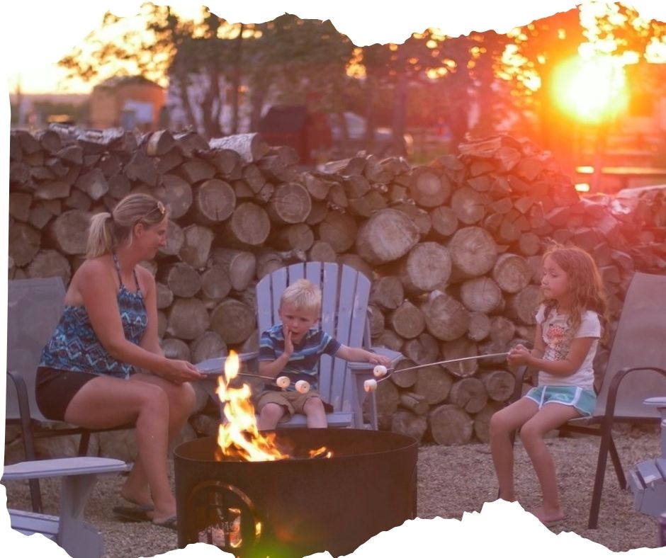 Family sitting around campfire roasting marshmallows